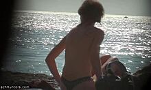Nudiste blonde se déshabille sur la plage