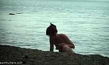 Karcsú csaj teljesen meztelen testét mutatja egy nudista strandon