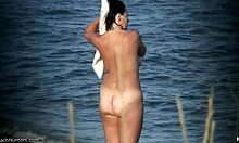 Naturliga bröst nudist visar upp sin kropp på en öde nudiststrand