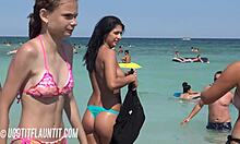 胸部丰满的棕发女郎在海滩上展示她的晒黑