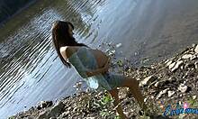 妊娠中のボムシェルが水辺で半裸の体を見せる